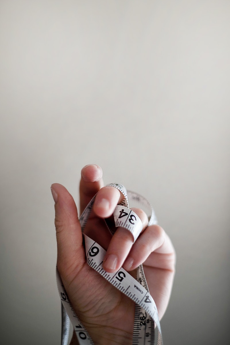 Photo by Jennifer Burk person's left hand wrapped by tape measure