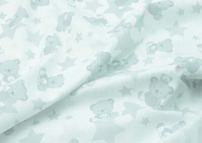 a close up of a white fabric with teddy bears on it